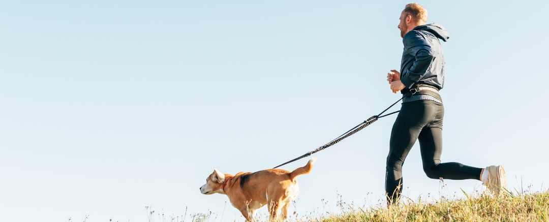 man and dog having a run outdoors